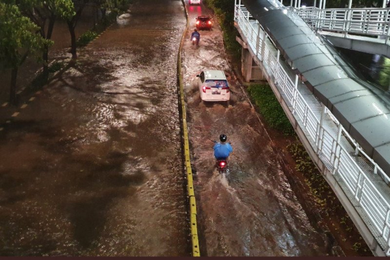 Pengendara melintas di dekat halte bus TransJakarta Cempaka Putih, Jakarta Pusat, yang terendam banjir setinggi 40-50 sentimeter, Selasa, 25 Februari 2020. (Foto:Antara)