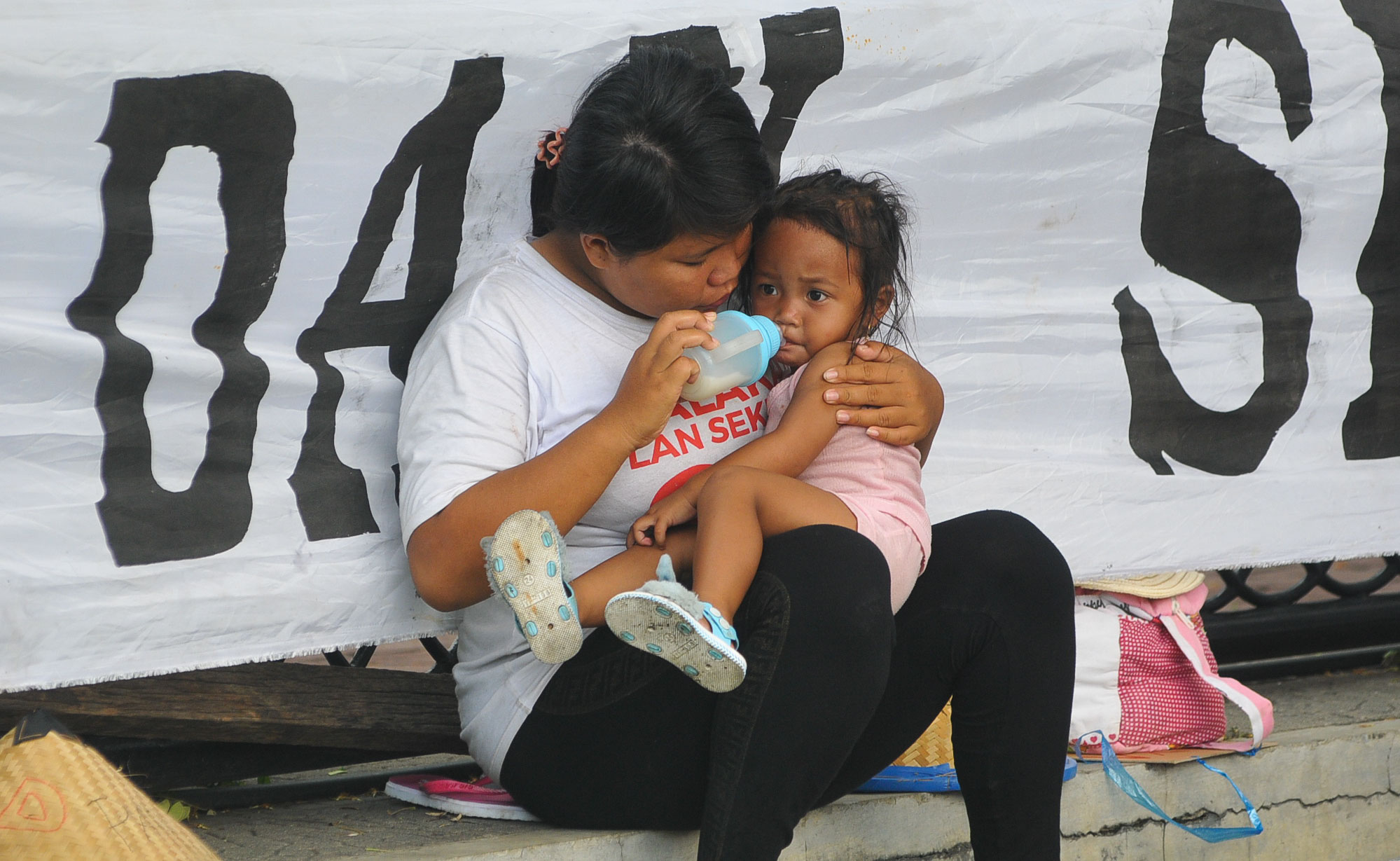 Disela-sela aksi demo warga Tumpang Pitu Banyuwangi, seorang ibu sedang memberi susunkepada anaknya. (foto : Erfan Hazransyah/ngopibareng.id)