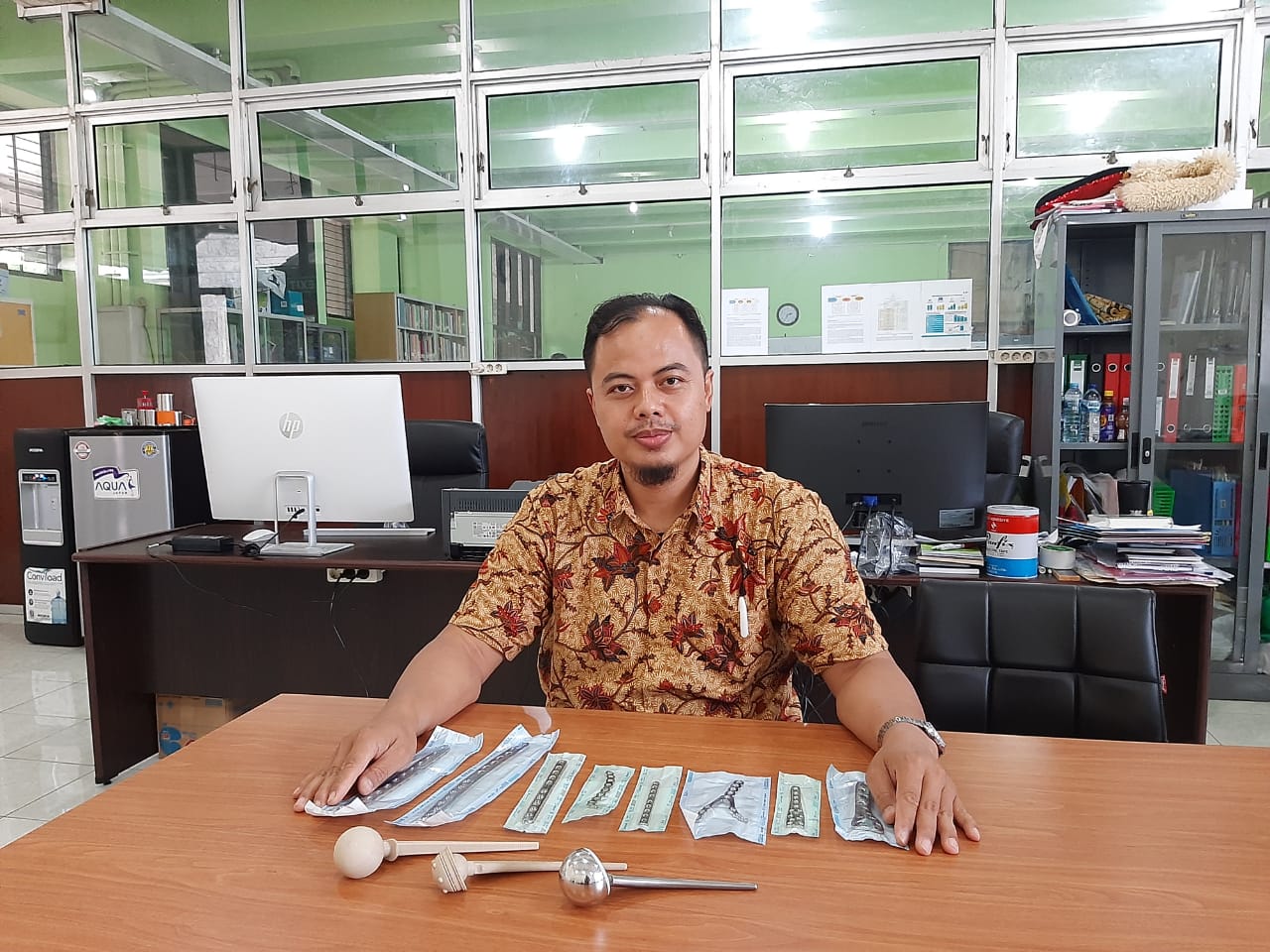 Fahmi Mubarok ST MSc PhD saat menunjukan implan lokal buatannya. (Foto: Istimewa)