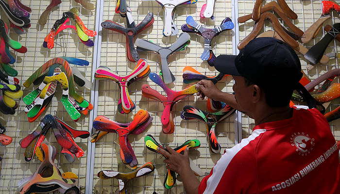 Harry Gunawan menata karya bumerang di rumahnya. (Foto: Erfan Hazransyah/Ngopibareng.id)