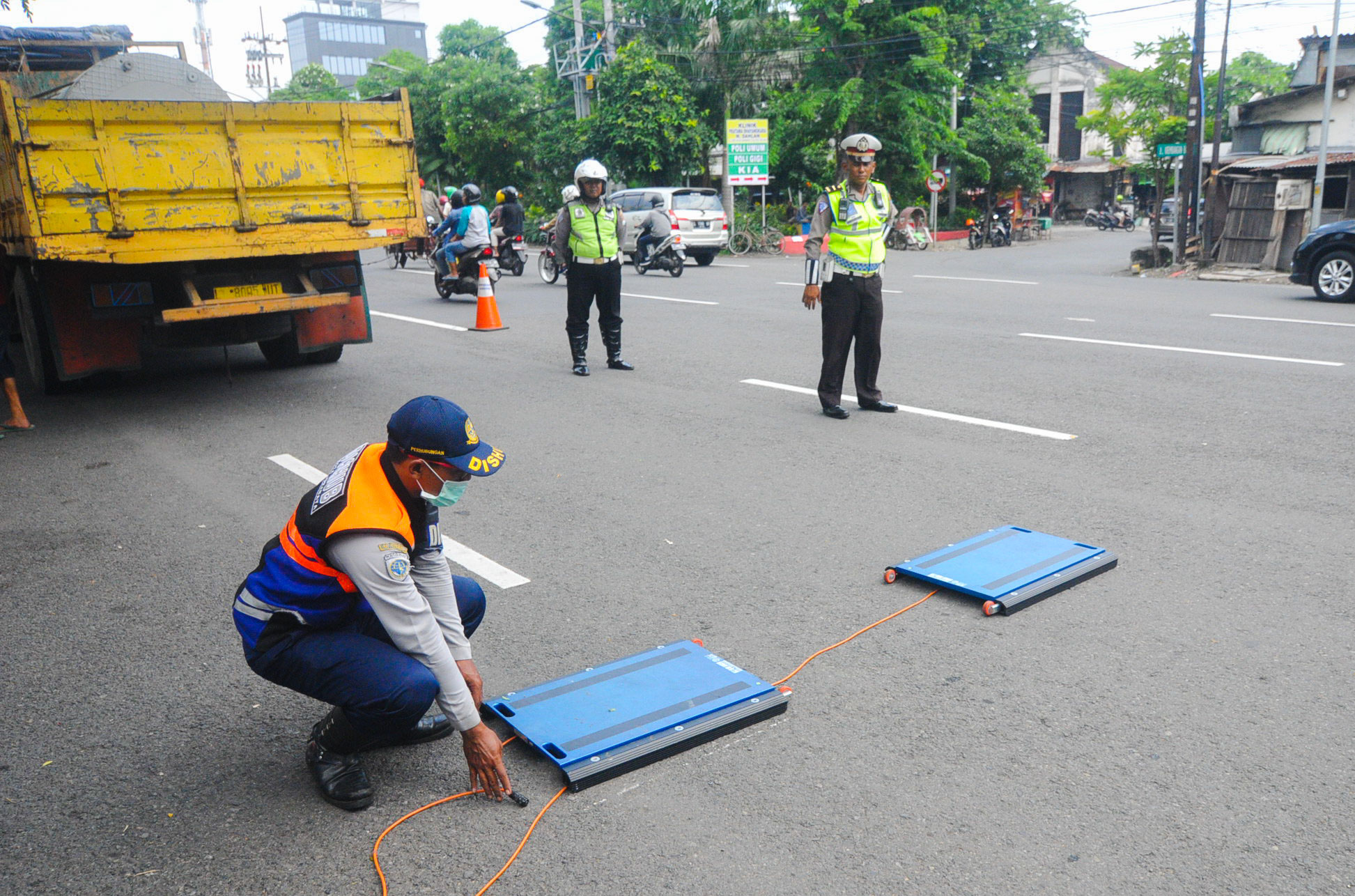 Seorang petugas dari Dishub kota Surabaya memasang alat uji berat kendaraan. (Foto: Erfan Hazransyah/ngopibareng.id)