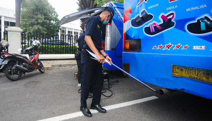 Petugas Dishub kota Surabaya menguji emisi atau ketebalan asap knalpot kendaraan angkutan orang dan barang di Jalan Indrapura, Surabaya. (Foto: Erfan Hazransyah/ngopibareng.id)