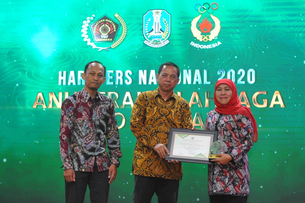 Gubernur Jatim, Khofifah Indar Parawansa menerima penghargaan dari Ketua PWI Jatim, Ainur Rohim didampingi Ketua SIWO PWI Jatim, Erwin Muhammad. (Foto: Erfan Hazransyah/Ngopibareng.id)