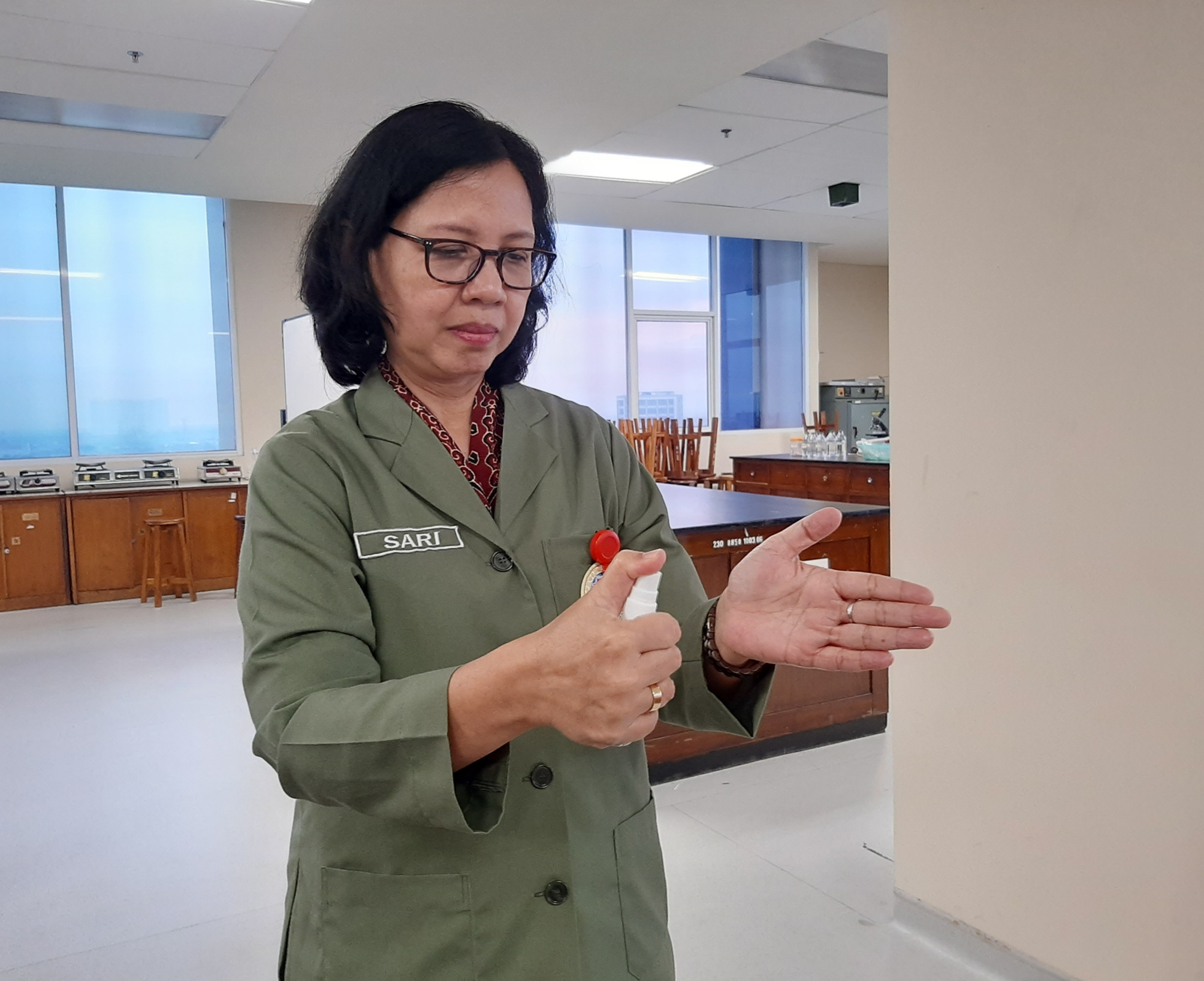 Ketua Departemen Farmasetika Fakultas Farmasi Unair (FFFU), Retno Sari, Dr., MSc., Apt. Saat mencoba hand sanitizer yang ia buat sendiri. (Foto: Pita Sari/Ngopibareng.id)