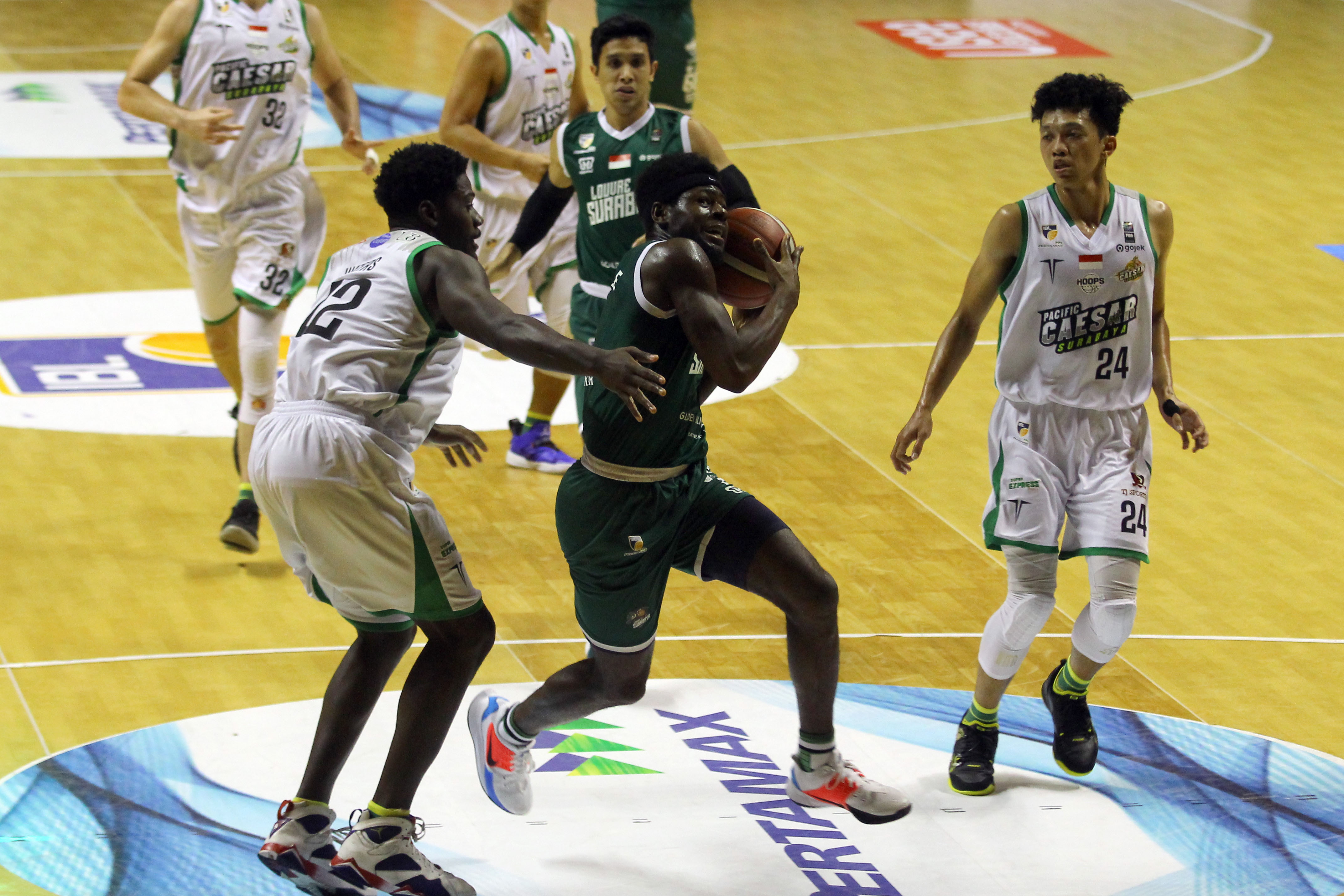 Pemain Louvre Surabaya, Michael Kolawole berhasil menembus pertahanan Pacific Caesar dalam laga seri enam IBL 2020 di DBL Arena, Surabaya, Minggu 8 Maret 2020. (Foto: Fariz Yarbo/Ngopibareng.id)