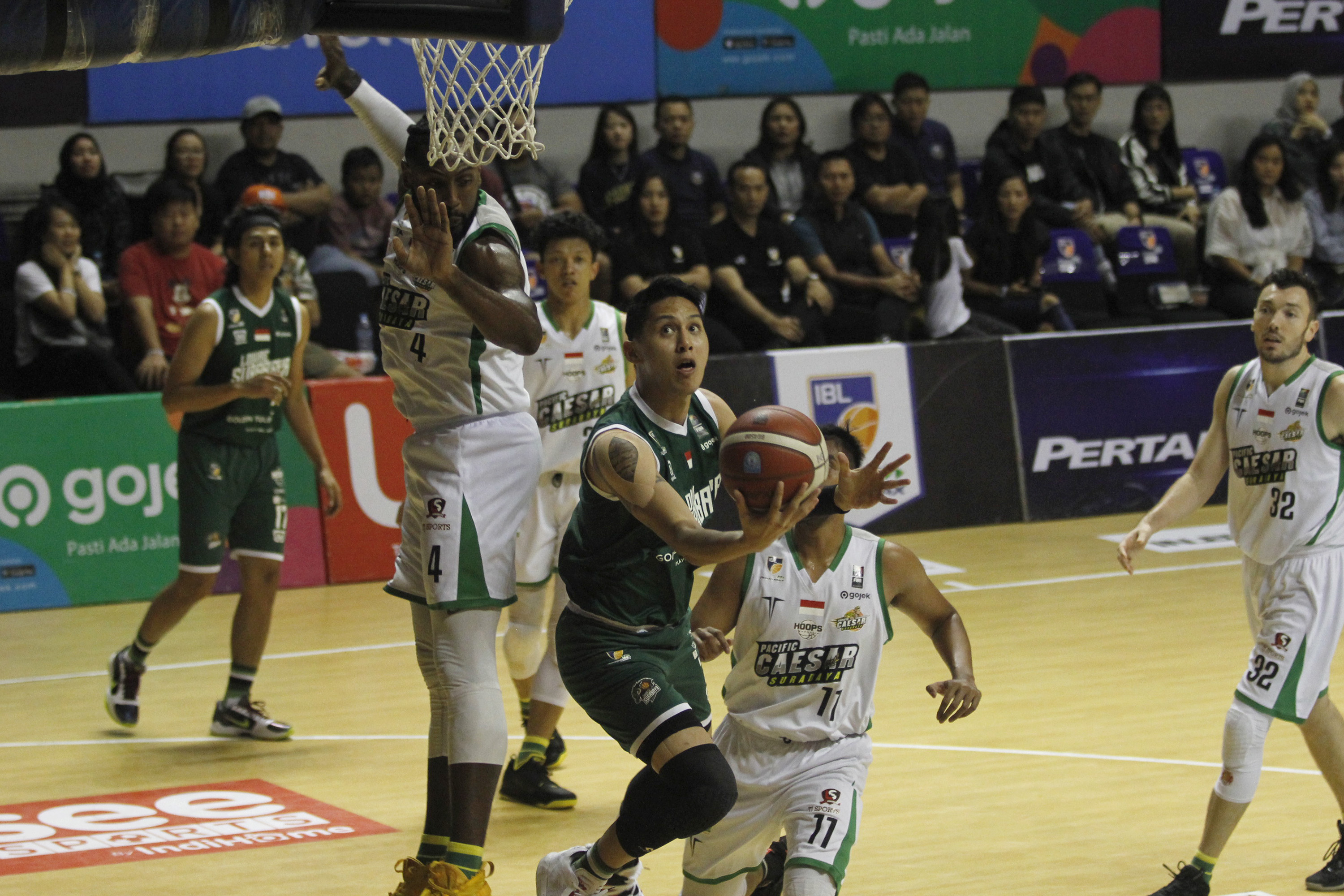 Pemain Louvre Surabaya, Daniel Timothy Wenas berusaha mencetak poin di tengah hadangan pemain Pacific Caesar dalam laga seri enam IBL 2020 di DBL Arena, Surabaya, Minggu 8 Maret 2020. (Foto: Fariz Yarbo/Ngopibareng.id)