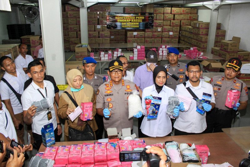 Petugas Kepolisian Resor Kota Sidoarjo Jawa Timur menujukkan barang bukti masker ilegal di salah satu pergudangan di Sidoarjo. (Foto: Ant)