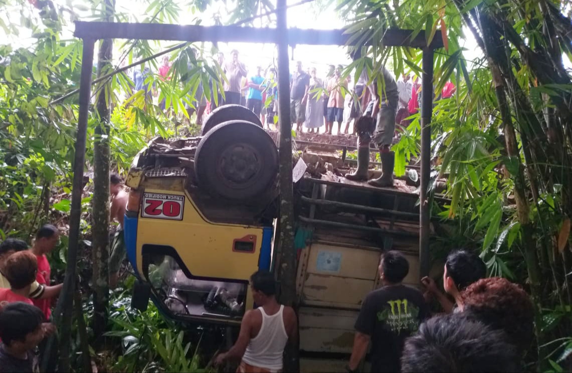 Petugas bersama warga mengevakuasi truk pengangkut buruh perkebunan yang terguling (foto: Muh Hujaini/Ngopibareng.id)