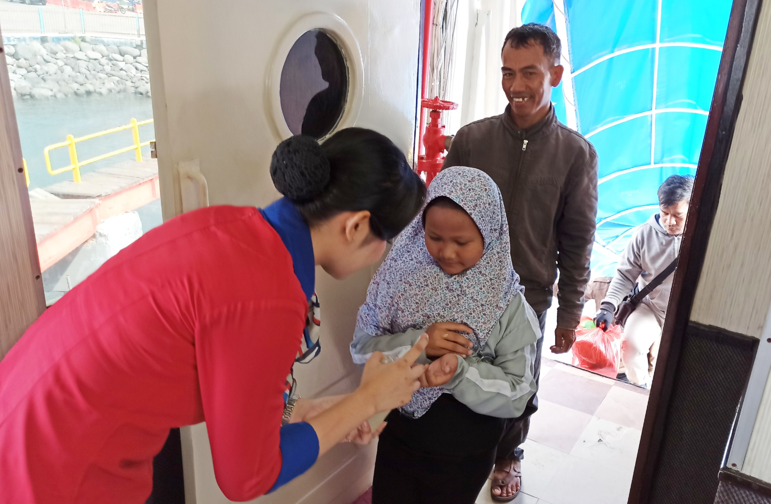 Petugas Kapal memberikan hand sanitizer kepada penumpang kapal di penyeberangan Ketapang-Gilimanuk (Foto: Muh. Hujaini/Ngopibareng.id)