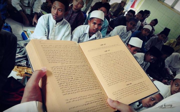 Para santri sedang menyimak seorang kiai untuk mengaji Kitab Kuning di pesantren. (Foto: Istiemwa)