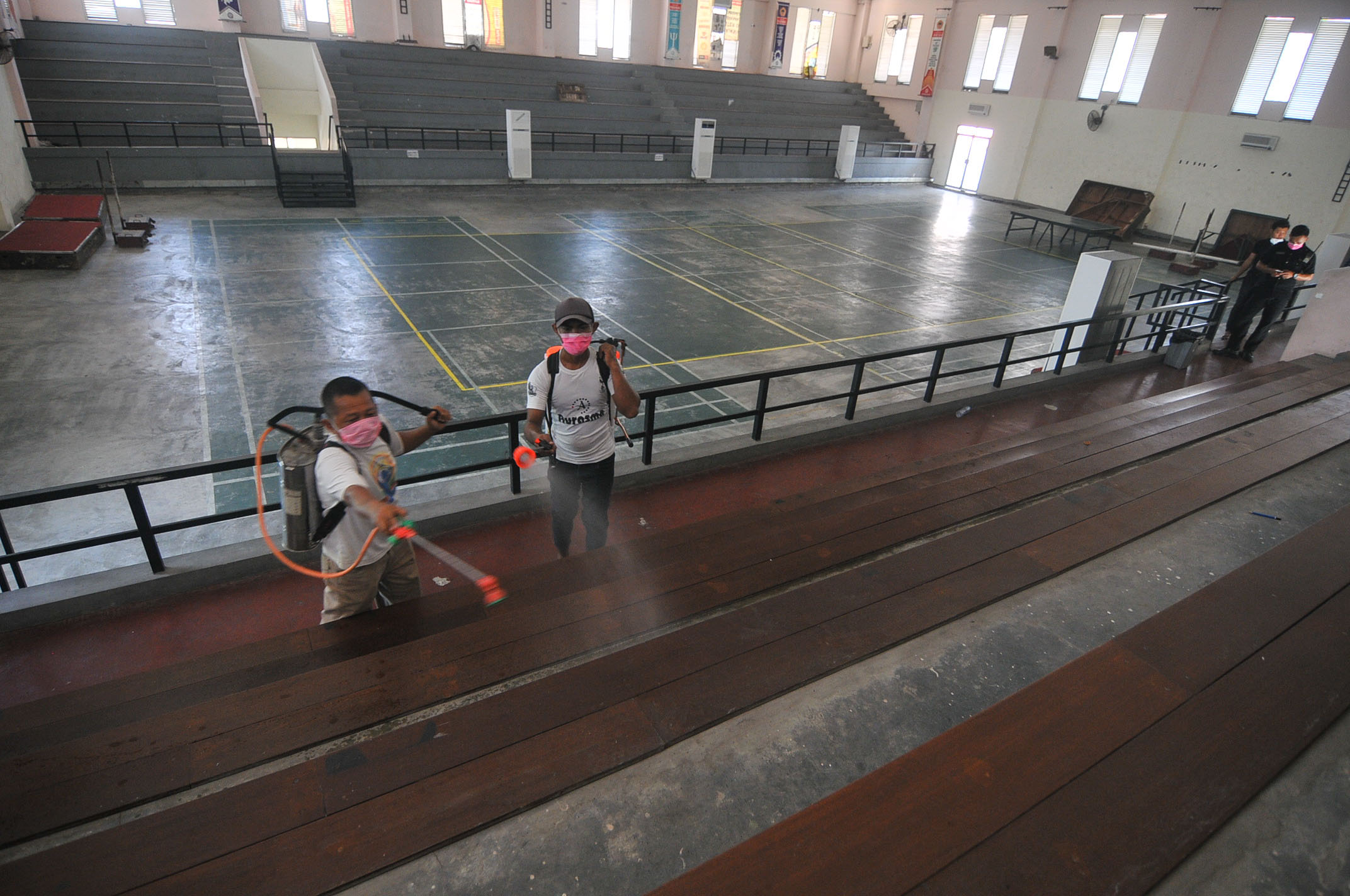 Petugas menyemprot disinfektan di area luar dan dalam sport center Untag. (Foto: Erfan Hazransyah/Ngopibareng.id)