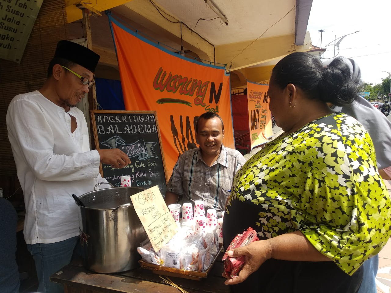 Kusnan Hadi saat bagikan wedang uwuh gratis di warung angkringannya. (Foto: Rizqi Mutqiyyah/Ngopibareng.id)