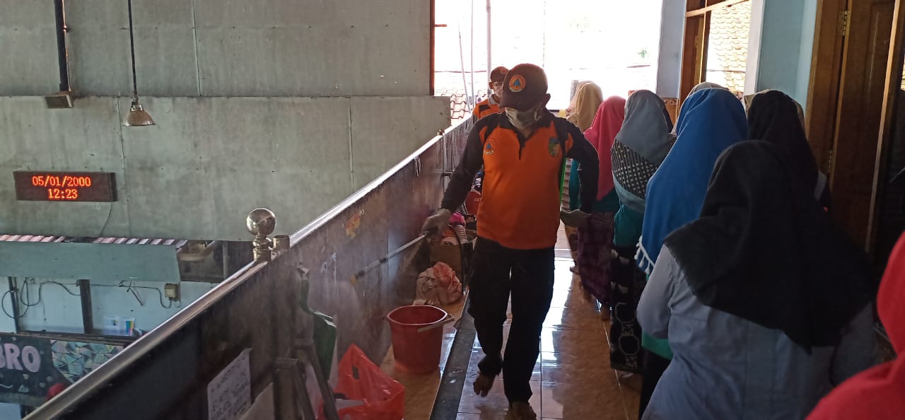 Petugas BPBD Kabupaten Kediri melakukan penyemprotan Ponpes puteri  Al Falah Ploso, Mojo, Kediri. (Foto: Fendhy Plesmana/Ngopibareng.id)