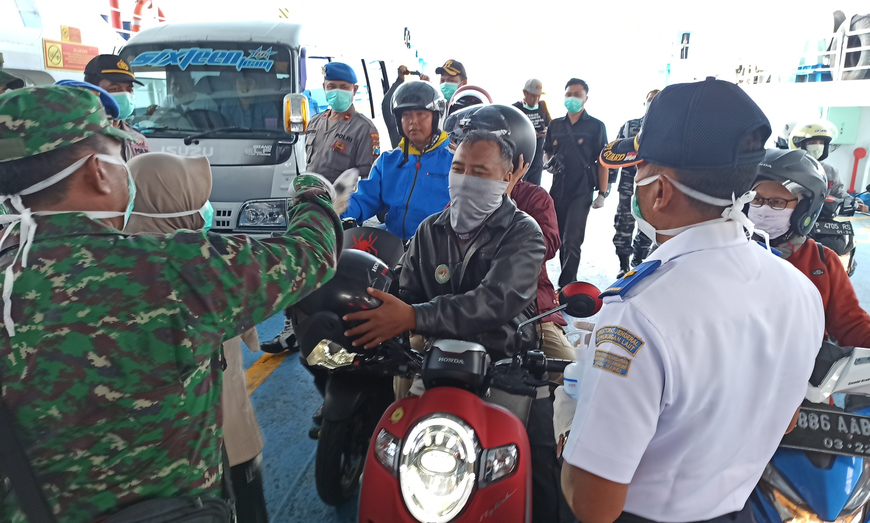 Pemudik dari Bali diperiksa suhu tubuhnya saat akan turun dari kapal penyeberangan (foto: Hujaini/ngopibareng.id))