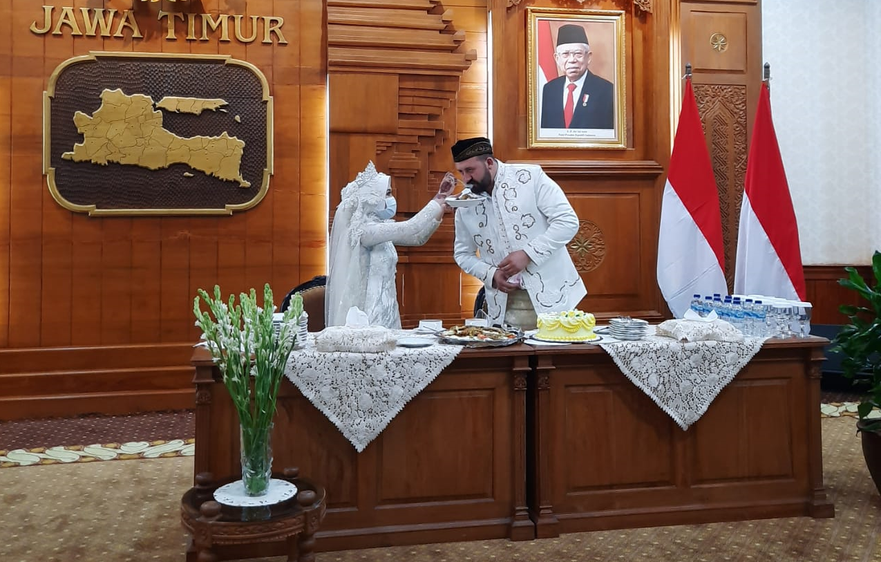 Irra Chorina Octora yang menyuapkan makanan ke suaminya, Yavuz Ozdemir. Gara-gara virus corona, pasangan ini melangsungkan resepsi pernikahan di Gedung Negara Grahadi. (Foto: Alief Sambogo/Ngopibareng.id)