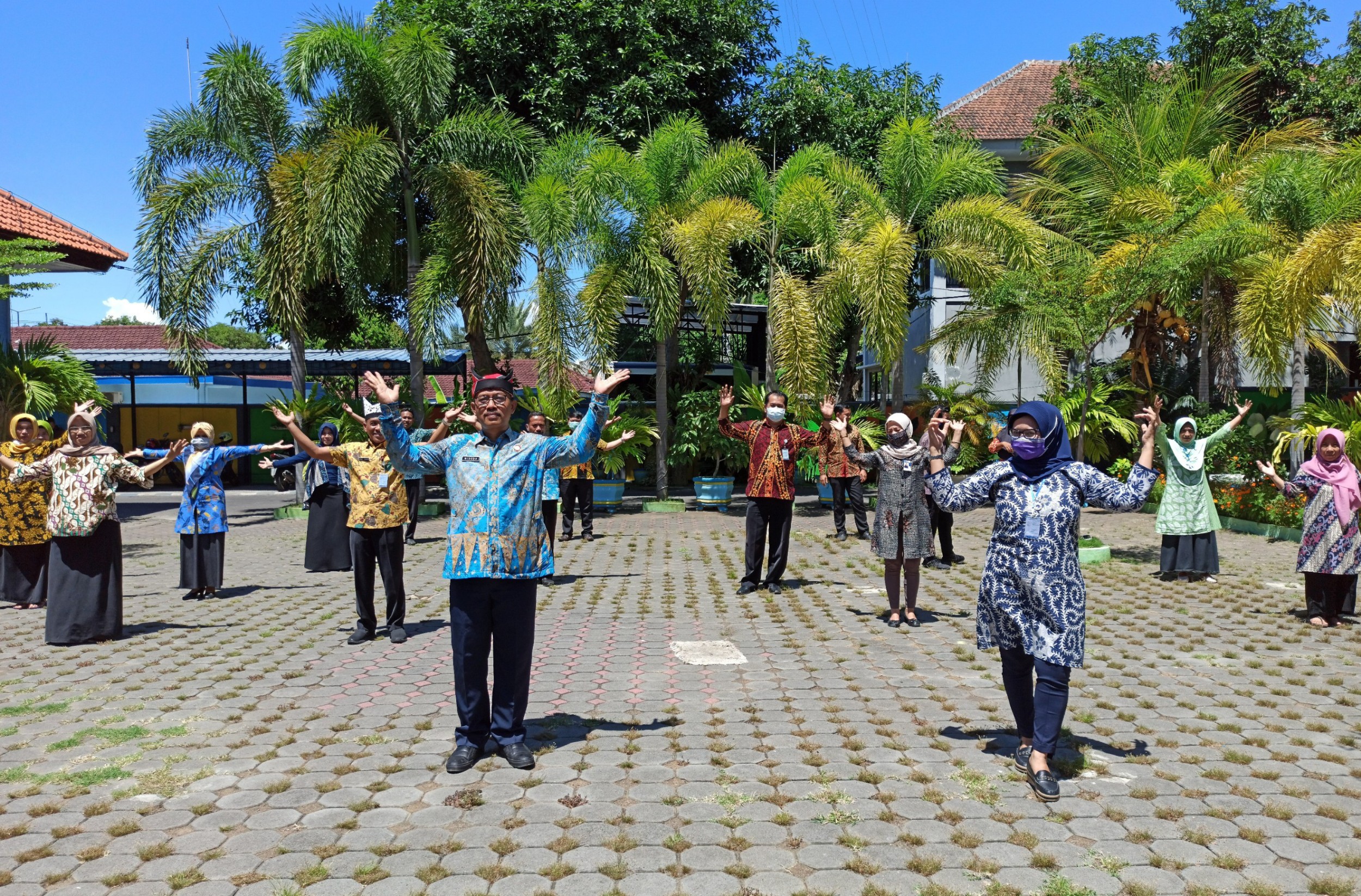 Pegawai Pudam Banyuwangi berjemur sambiko bermain tiktok untuk meningkatkan imun (foto: Hujaini/ngopibareng.id)