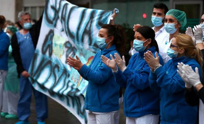 Tenaga medis di Kota Madrid, Spanyol, sedang  bertepuk tangan untuk menyambut dorongan semangat dari warga Spanyol yang berada di balkon-balkon tempat tinggal mereka.  (Foto:Sergio Perez/Reuters)