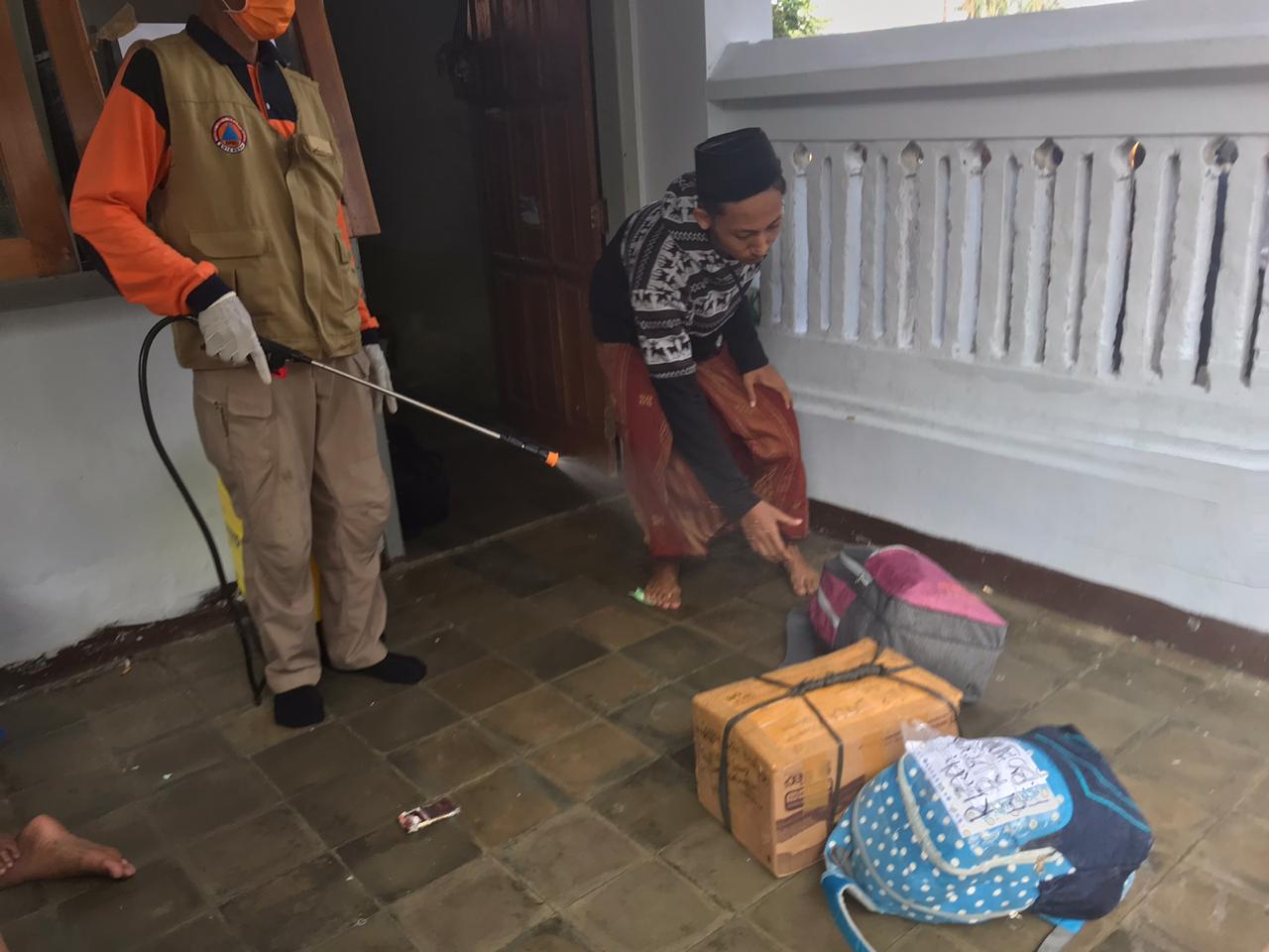 BPBD melakukan penyemprotan barang bawaan para santri (foto istimewa) 