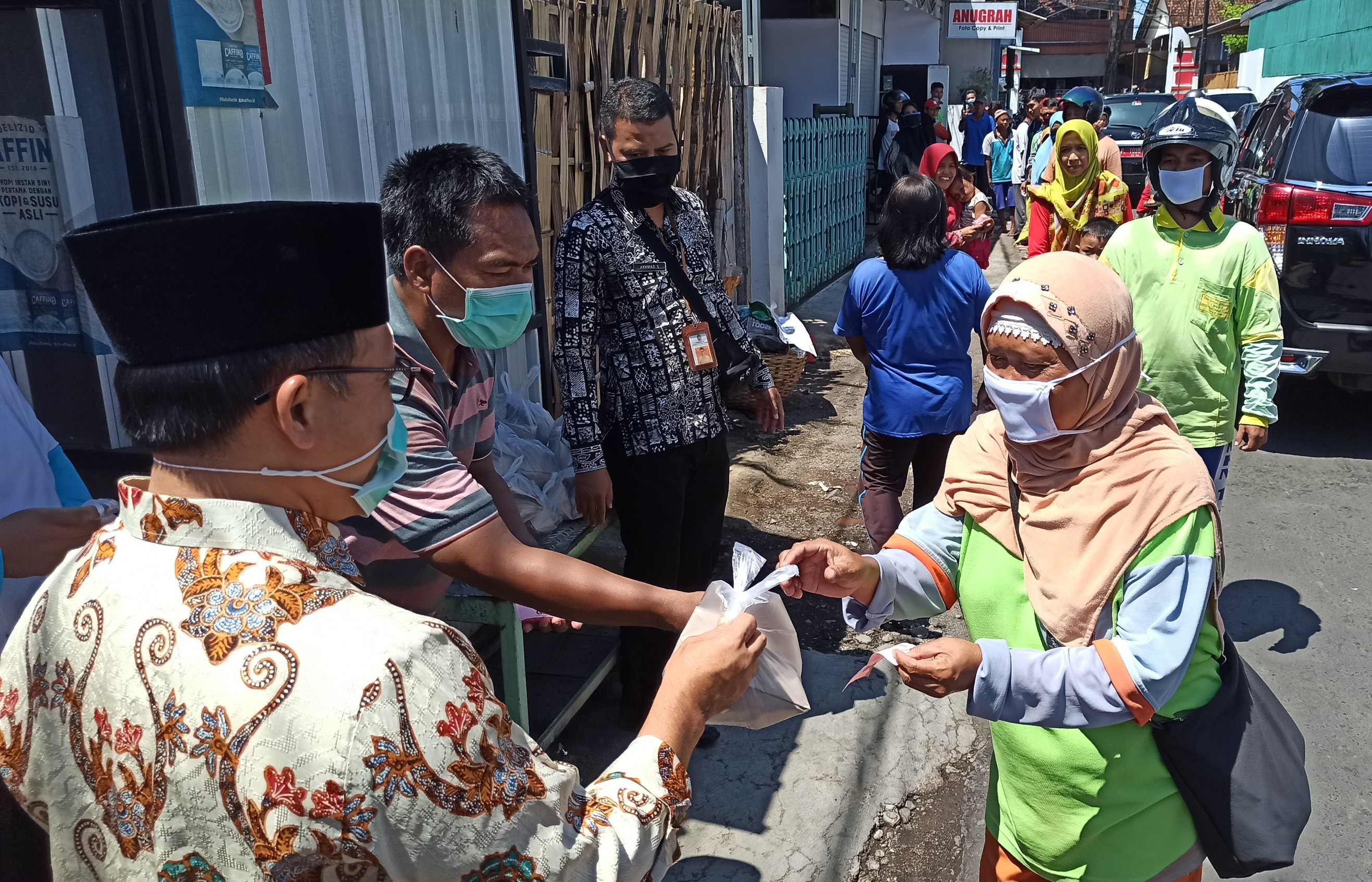 Bupati Banyuwangi Abdullah Azwar Anas menyerahkan nasi bungkus pada warga terdampak Covid-19. (Foto: Muh Hujaini/Ngopibareng.id)