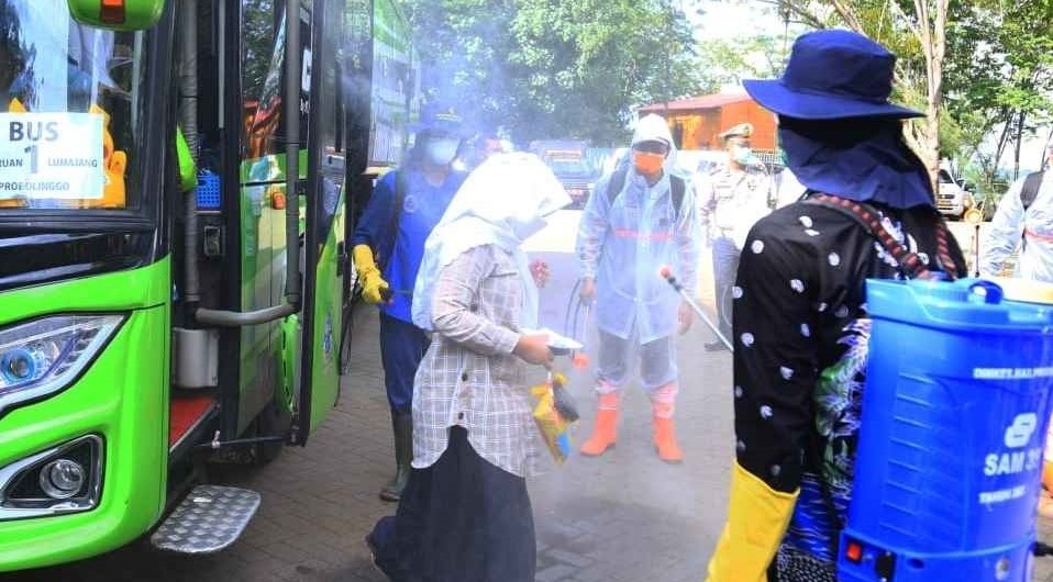 Penumpang bus dari luar daerah yang turun di Kabupaten Probolinggo disemprot disinfektan, akhir Maret lalu. (foto: Ikhsan Mahmudi/Ngopibareng.id)