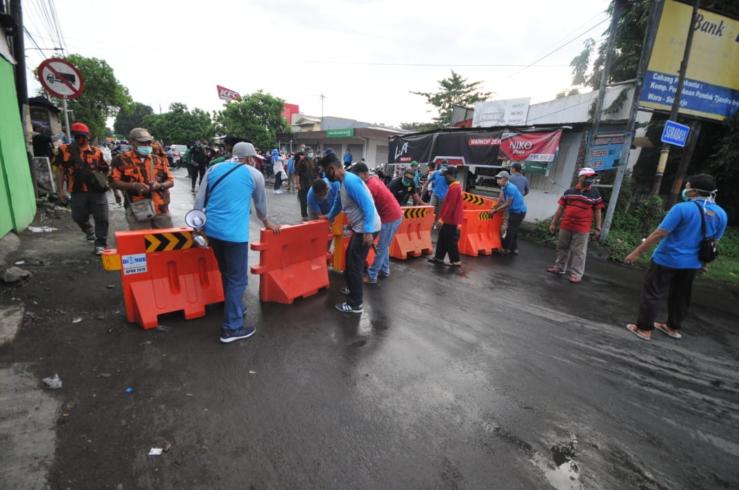 Penutupan jalan oleh warga karena kebijakan social distancing (Foto: Erfan Hazransyah/Ngopibareng.id)