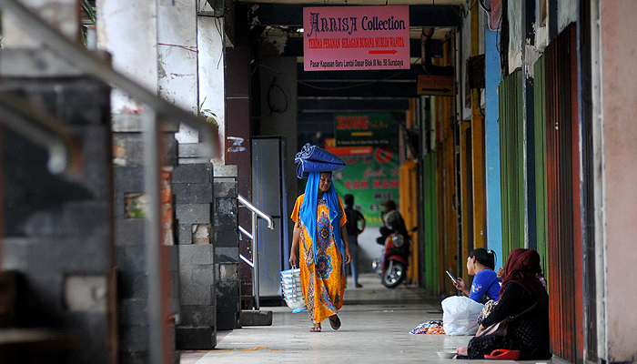 Beberapa orang yang biasa berativitas di Pasar Kapasan Surabaya hanya bisa duduk-duduk di lorong depan pasar. (Foto: Erfan Hazransyah/Ngopibareng.id)