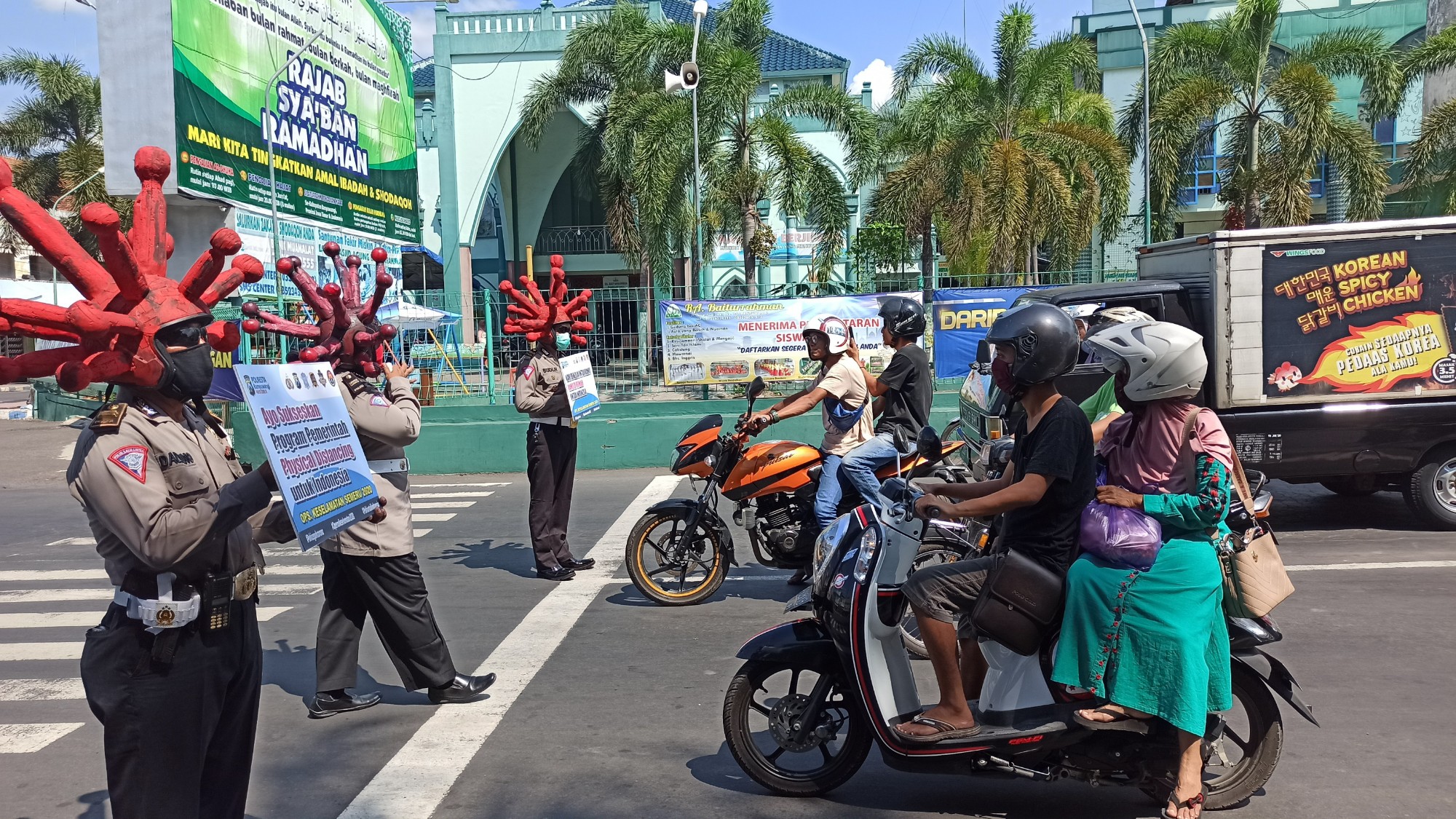 Polisi melakukan sosialisasi pencegahan Covid-19 dengan menggunakan atribut mikroskopik virus Corona (foto: Hujaini/ngopibareng.id) 