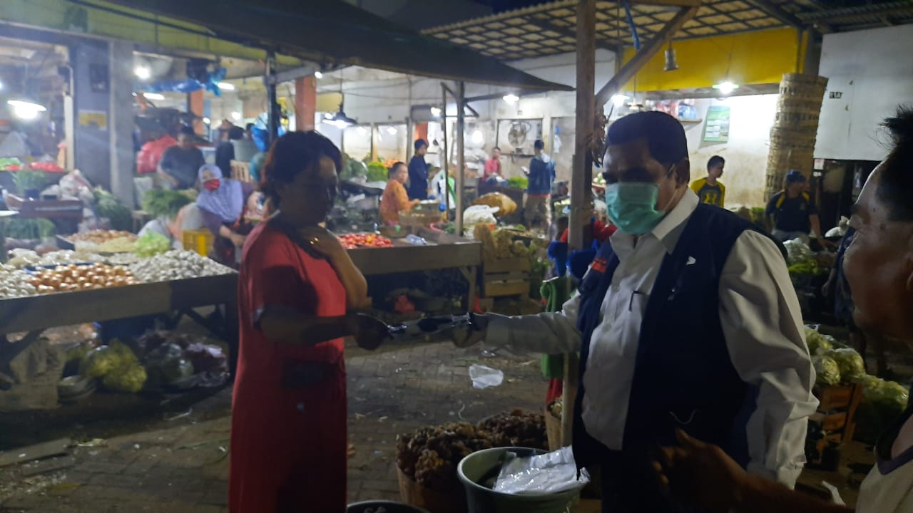 Kadisperindag Pemprov Jawa Timur Drajat Irawan membagikan masker ke pedagang di Pasar Keputran, Jumat 17 April 2020. (Foto: Alief Sambogo/Ngopibareng.id)