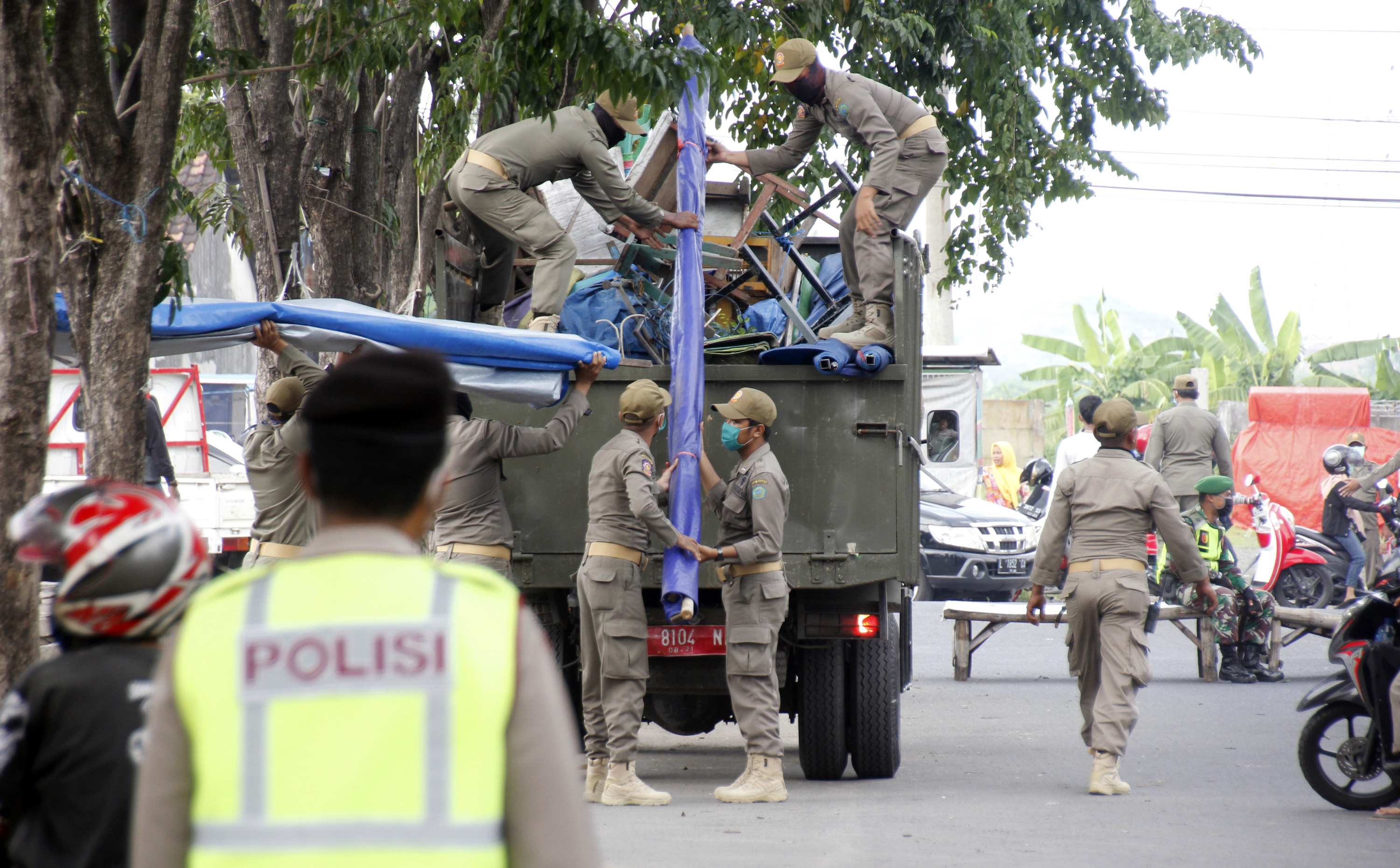 Petugas Satpol PP Sidoarjo mengangkut barang-barang milik pedagang yang nekat berjualan di Kawasan Gading Fajar 2, Sidoarjo, Minggu 19 April 2020. (Foto: Fariz Yarbo/Ngopibareng.id))