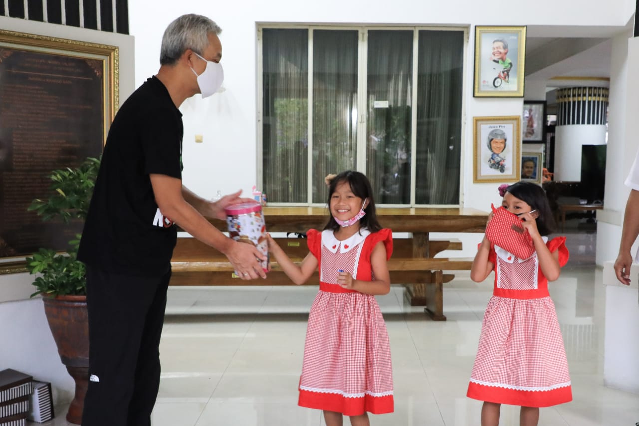 Gubernur Jawa Tengah Ganjar Pranowo ketika memberikan sumbangan uang celengan dari dua orang bocah. (Foto: Ngopibareng.id)