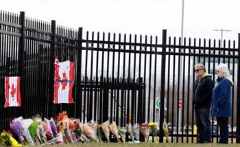 Dua warga mengheningkan cipta di lokasi mengenang korban tewas penembakan massal termasuk seorang polisi wanita Heide Stevenson di pagar Markas Besar Royal Canadian Mounted Police (RCMP) di Dartmouth, Nova Scotia, Kanada, Senin kemarin. (Foto:Reuters)