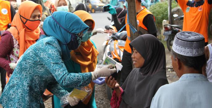 Ketua TP PKK Pasuruan Lulis Irsyad Yusuf membagikan masker dan jamu tradisional kepada warga terdampak Covid-19. (Foto: Dok Humas)