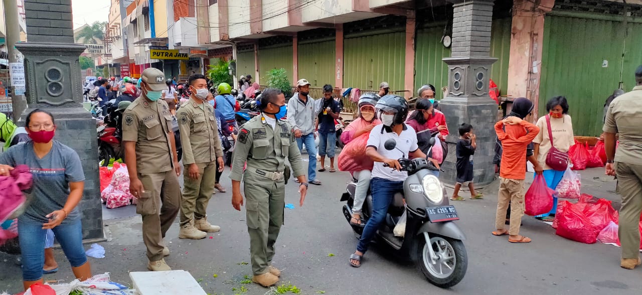 Petugas Satpol PP saat menata pedagang bunga musiman. (Foto: Fendhy Plesmana/Ngopibareng.id)