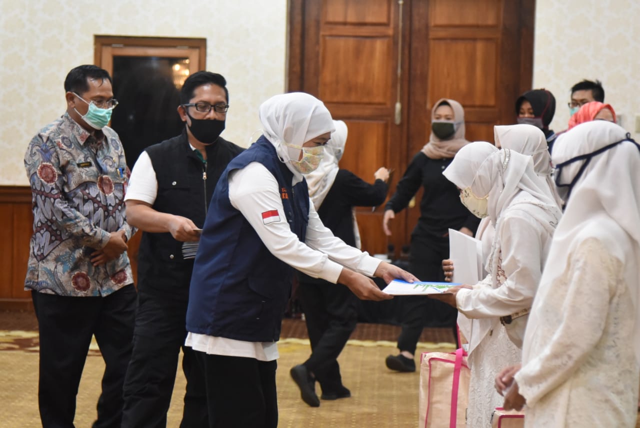 Gubernur Jawa Timur Khofifah Indar Parawansa, didampingi Kabiro Kesos Jatim Hudiyono memberikan tunjangan kehormatan kepada para hafidz dan hafidzah Quran Jawa Timur. (Foto: Alief Sambogo/Ngopibareng.id)