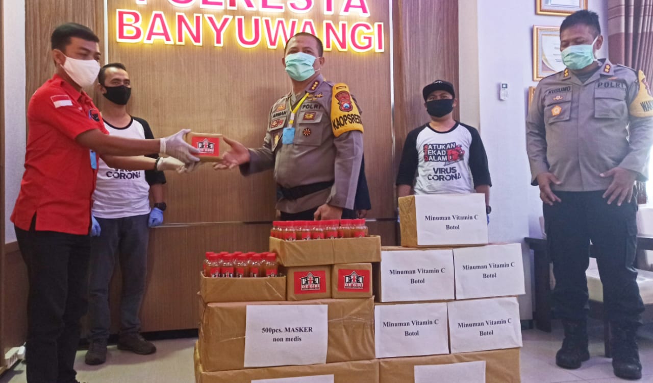 Koordinator Rumah De Giri menyerahkan bantuan vitamin hingga Hazmat pada Kapolresta Banyuwangi, Jawa Timur. (Foto: Muh Hujaini/ngopibareng.id)