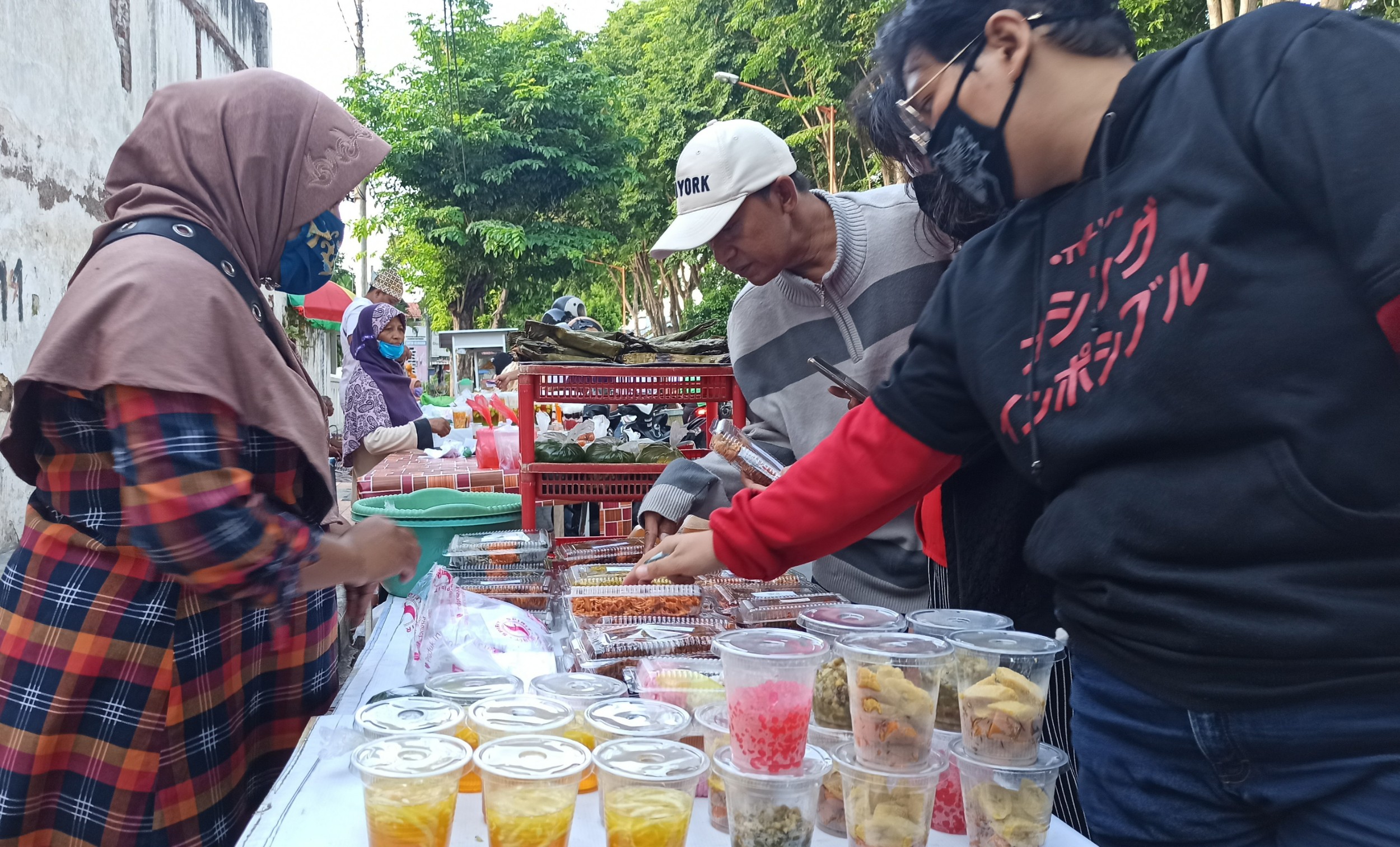 Sejumlah pembeli sedang memilih takjil dan lauk untuk buka puasa. (Foto: Hujaini/Ngopibareng.id)