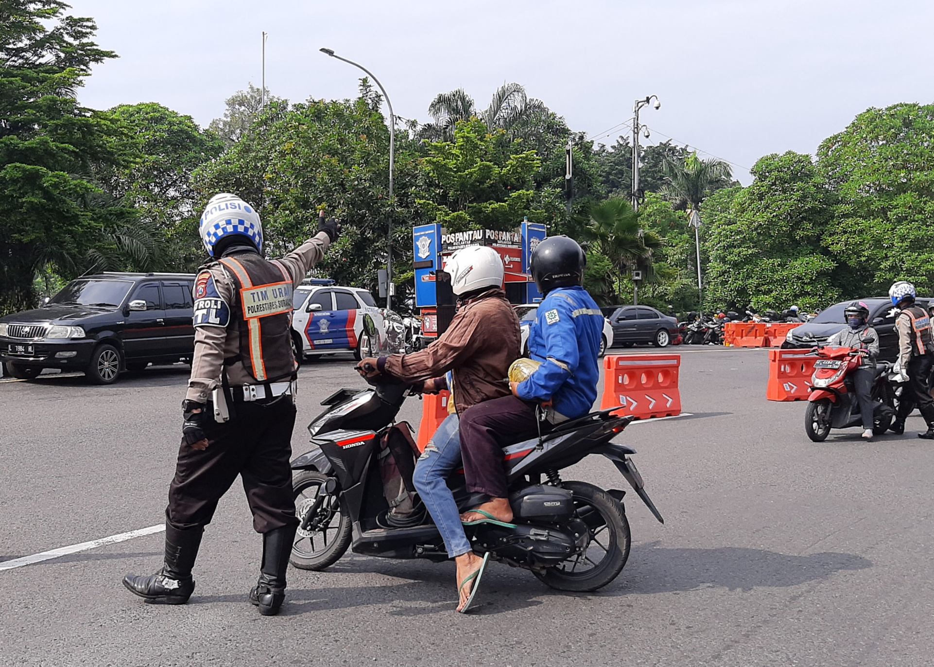 Petugas saat menginstrùksikan putar balik bagi warga yang tidak membawa surat tugas. (Foto: Pita Sari/Ngopibareng.id)