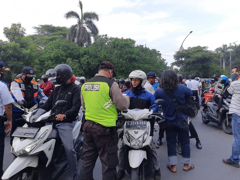 Kepolisian melakukan pemeriksaan terhadap pengendara yang bukan plat L di Bundaran Waru. (Foto: Pita Sari/Ngopibareng.id)