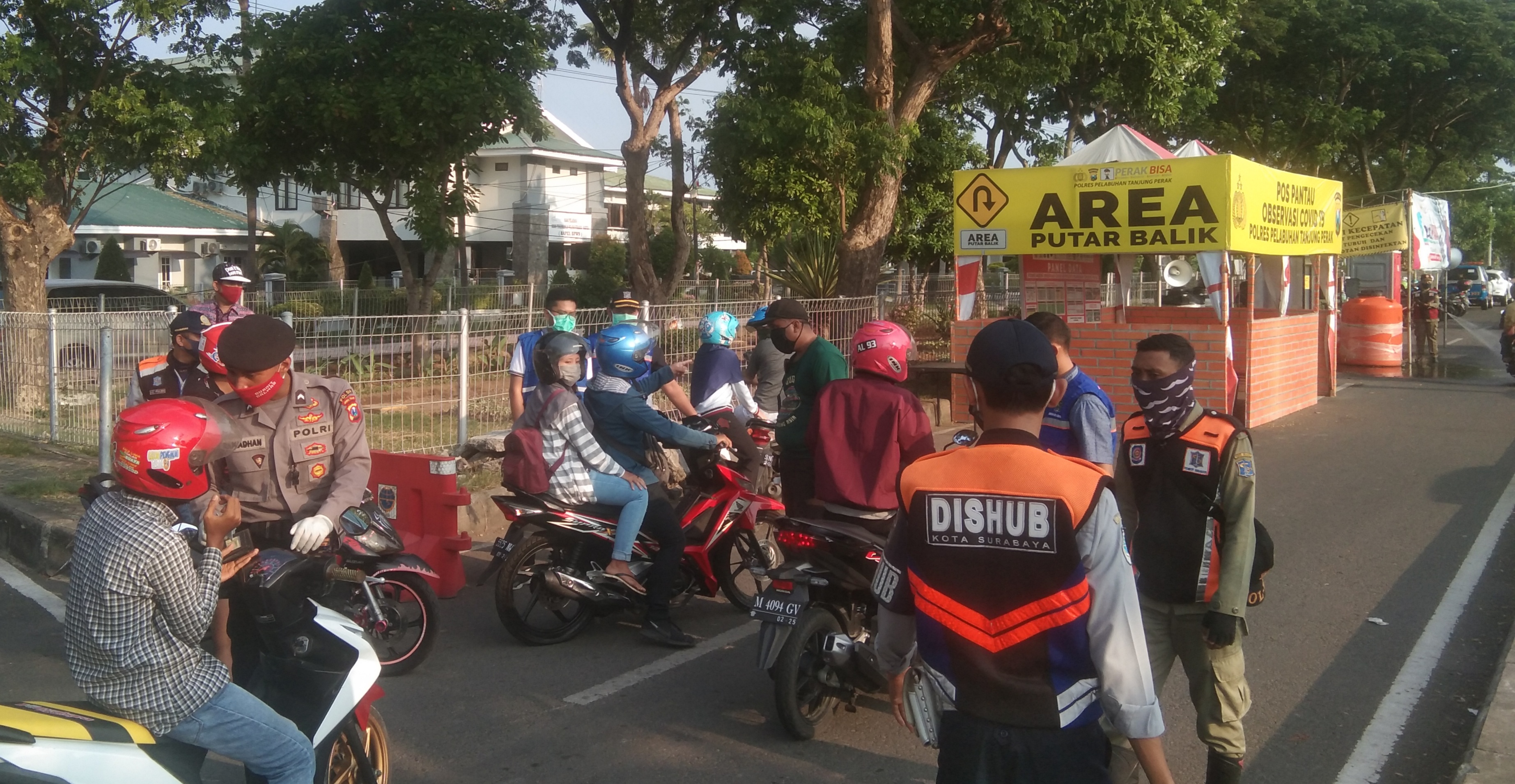 Sejumlah personil dsri Kepolisian, Satpol PP dan Dinkes Kota Surabaya saat melakukan pengecekan terhadap pengendara di pos check point dari arah Suramadu (Ni'am Kurniawan/ngopibareng.id)