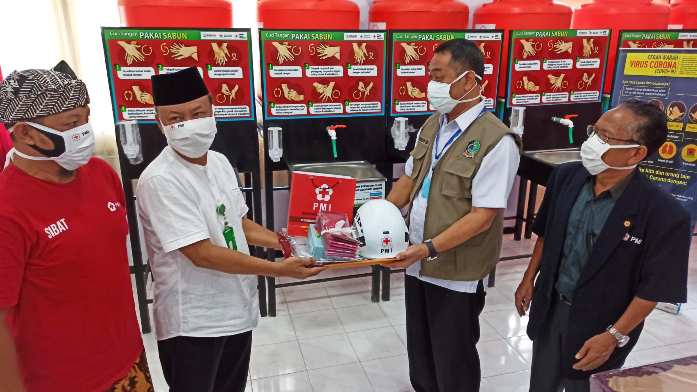 Ketua PMI Banyuwangi Yusuf Widyatmoko menyerahkan bantuan dari Palang Merah AS ke perwakilan wilayah yang mendapatkan bantuan. (Foto: Muh. Hujaini/Ngopibareng.id)