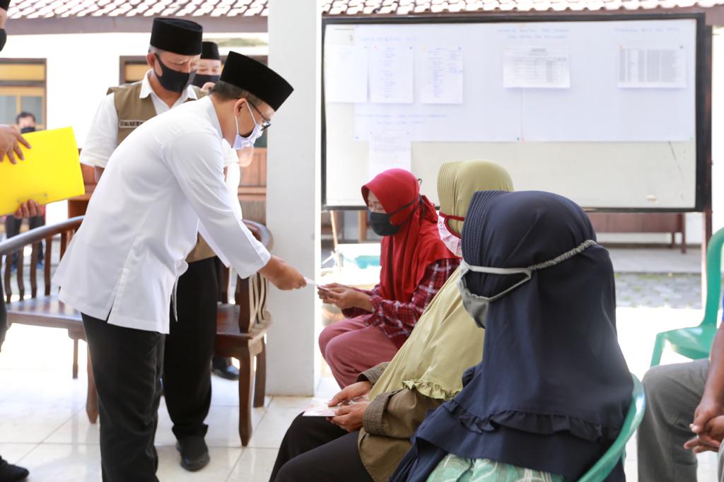 Bupati Banyuwangi Abdullah Azwar Anas menyerahkan bantuan dari Kementerian Sosial kepada warga. (Foto: Istimewa)