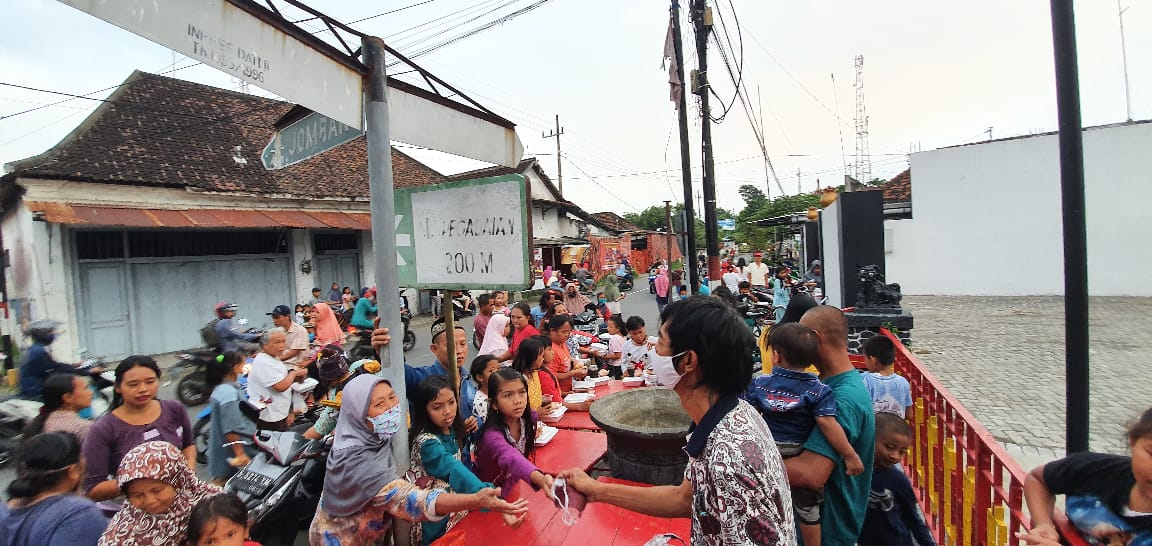 Sejumlah murid keagamaan Khonghucu membagikan nasi kotak dan masker di pelataran kelenteng Hong San Kiong, Gudo Jombang (Foto: M. Rizqi/Ngopibareng.id)