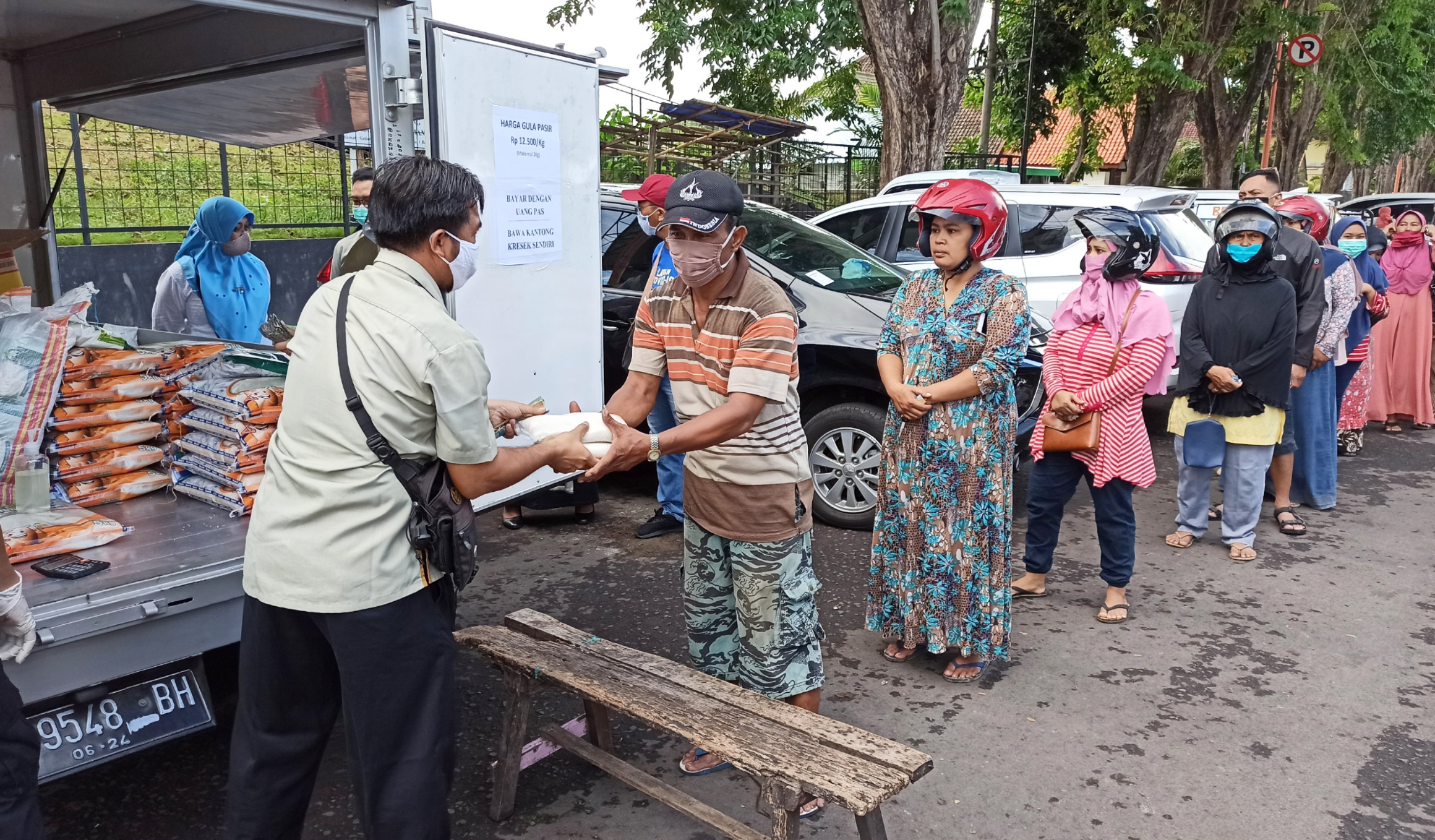 Warga antre membeli gula pasir pada operasi pasar yang digelar Bulog (Foto: Muh. Hujaini/Ngopibareng.id)