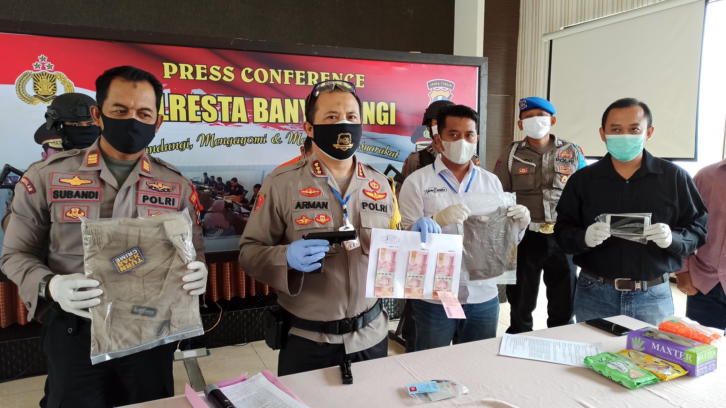 Kapolresta Banyuwangi Kombespol Arman Asmara Syarifuddin menunjukkan barang bukti uang dan air soft gun yang disita dari pelaku. (Foto: Muh Hujaini/Ngopibareng.id)