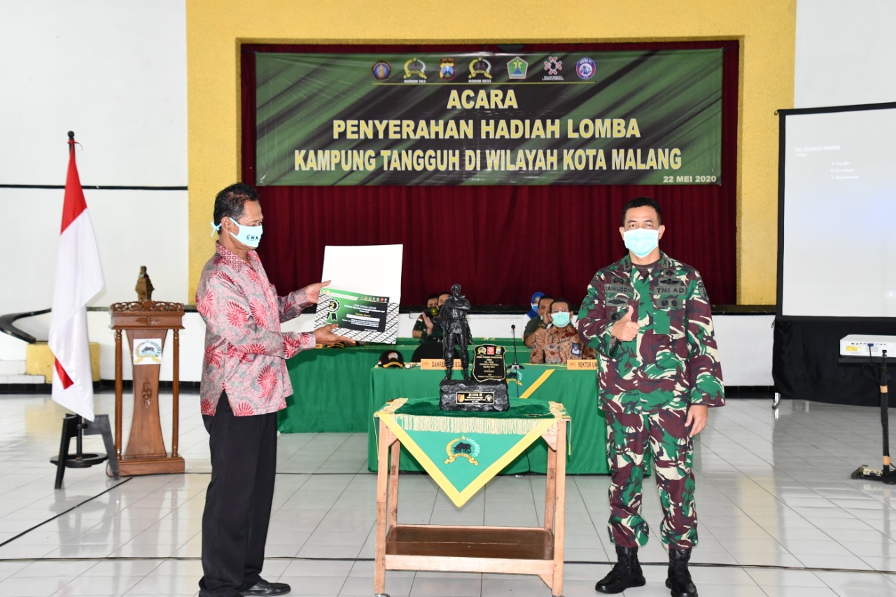 Ketua RW 04 Kampung Tangguh Tambaksari, Sugiyanto ketika menerima penghargaan Juara 1 Kampung Tangguh di Aula Skodam Brawijaya Malang, Jawa Timur. (Foto: Istimewa)