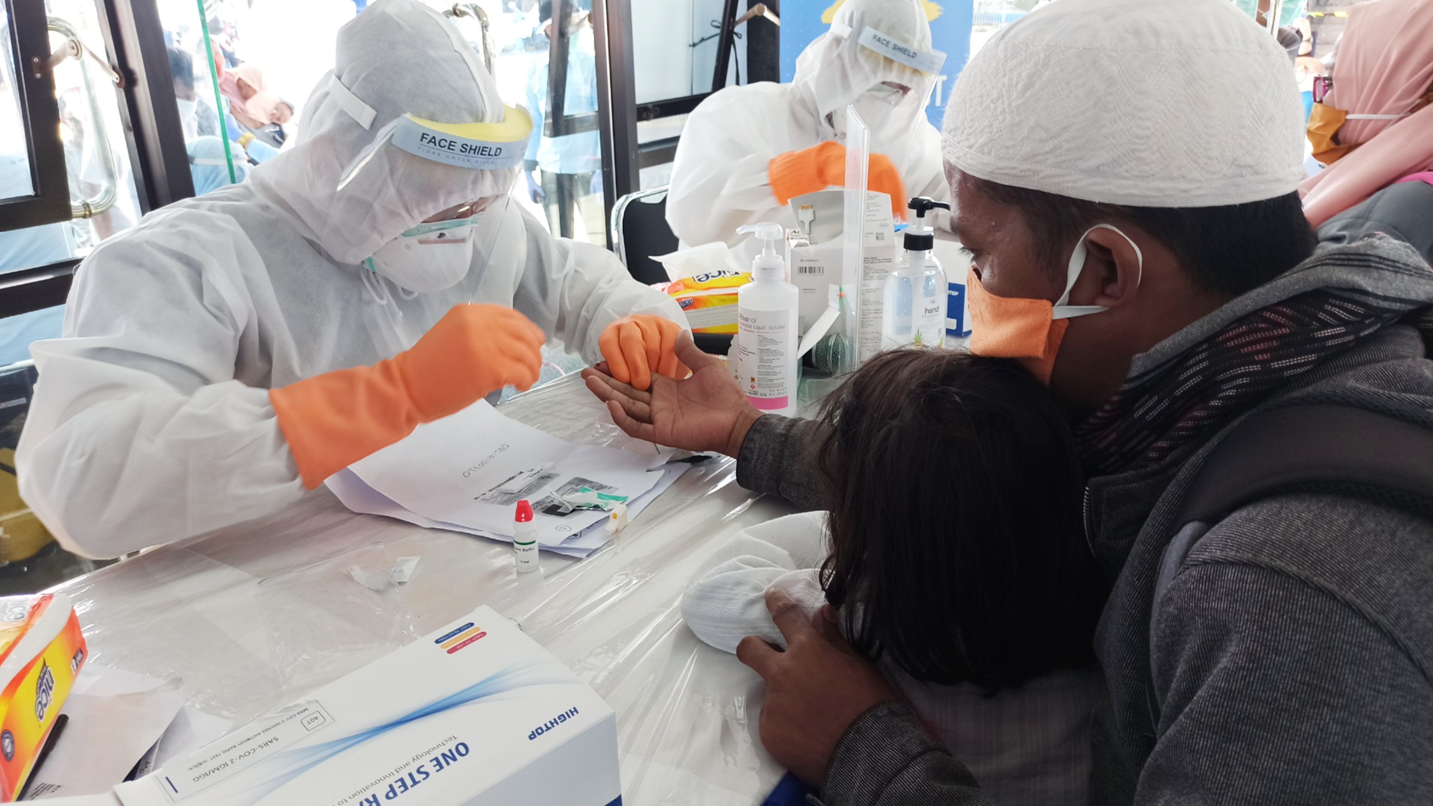 Salah satu calon penumpang menjalani rapid test bersama  anaknya di Pelabuhan Penyeberangan Ketapang, Banyuwangi, Jawa Timur. (Foto: Muh Hujaini/Ngopibareng.id)