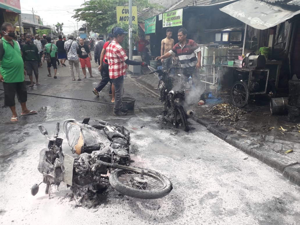 Warga membantu proses pemadaman api di sebuah kios bensin di kawasan Jalan Lebak Jaya Utara, Surabaya, Selasa 2 Juni 2020. (Foto: Dinas PMK Surabaya)