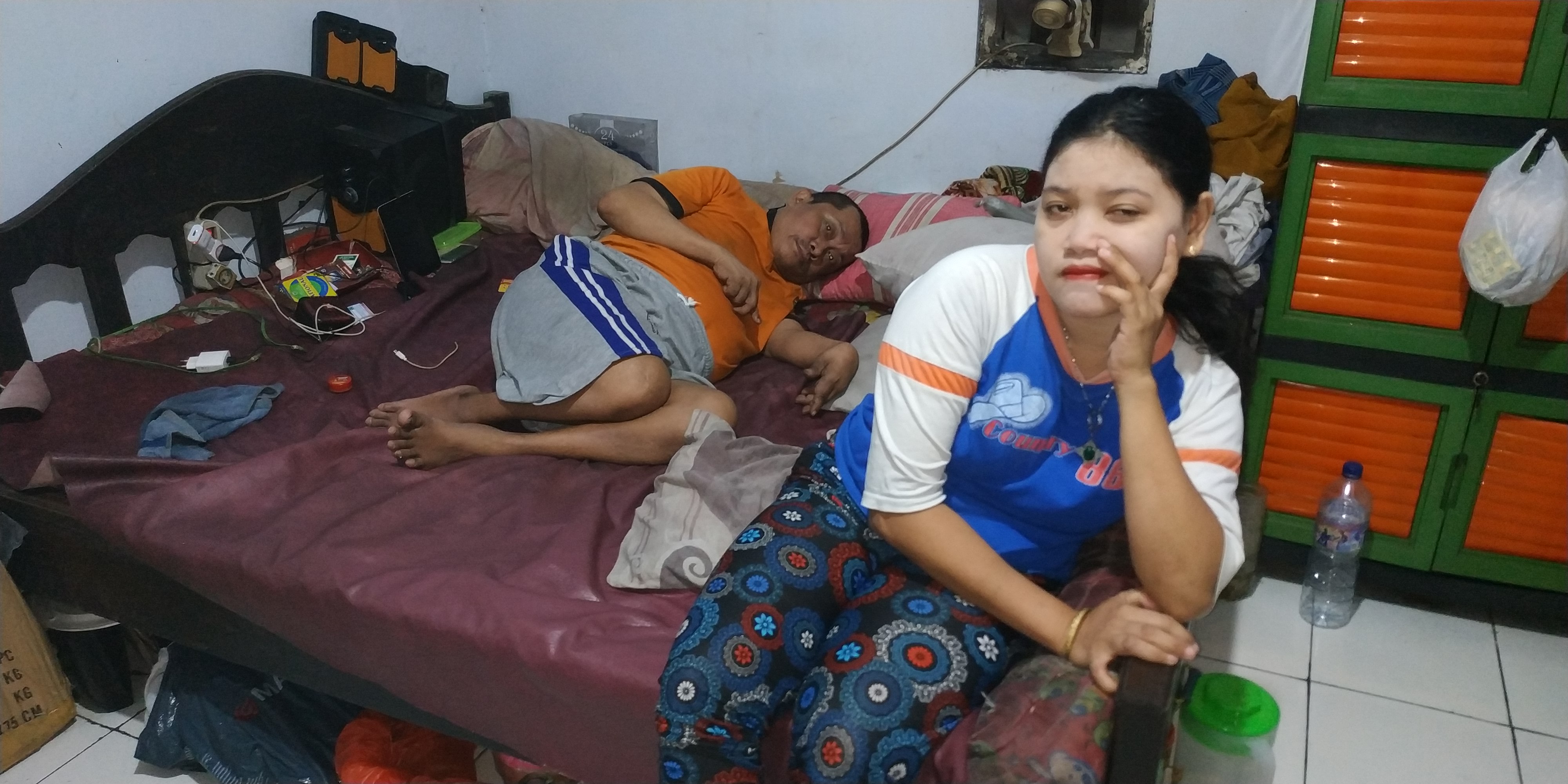 Suami Kasiani terbaring di tempat tidur karena stroke yang diderita hampir 4 tahun. (Foto: Fendhy/Ngopibareng.id)