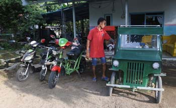 Sasmito bersama mobil dan sepeda listrik buatannya di depan rumahnya di Desa Wonoasri, Tempurejo, Jember, Jawa Timur, Rabu siang. Foto:Antara/Seno)