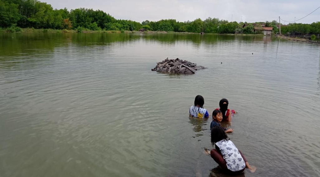 Sejumlah anak bermain di pinggir tambak udang yang terendam banjir rob di Desa Sidopekso, Kecamatan Kraksaan, Kabupaten Probolinggo. (Foto: Ikhsan Mahmudi/Ngopibareng.id)